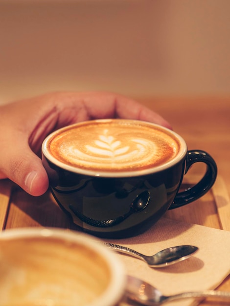 Man39s hand drinken van een kopje koffie met melk Energie in de ochtend ontbijt