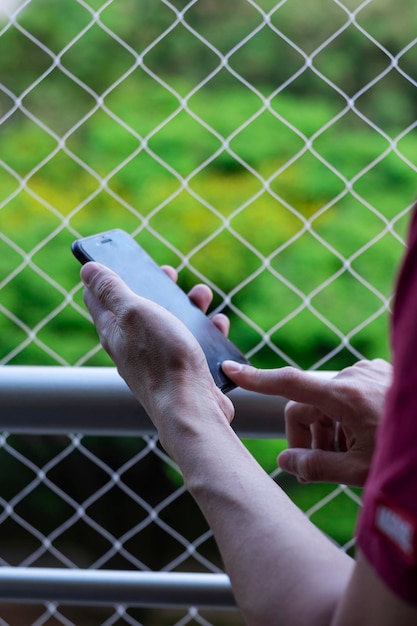 Man39s hand met mobiele telefoon op balkon met veiligheidsnet voor huisdieren