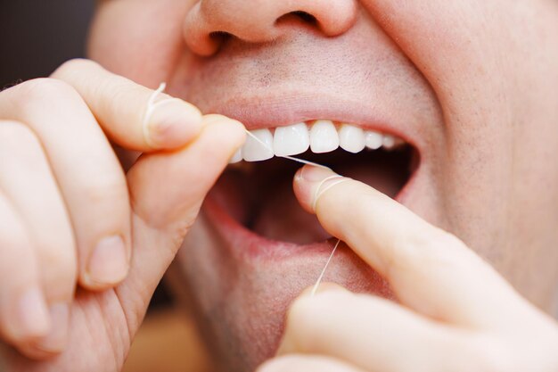 Photo a man39s mouth closeup a man brush your teeth with dental floss