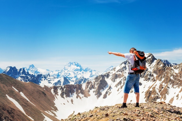 Manâs hike to the top of the mountain, success, winner, a man with a backpack stands on top of the mountain. mountains of Karachay-Cherkessia.