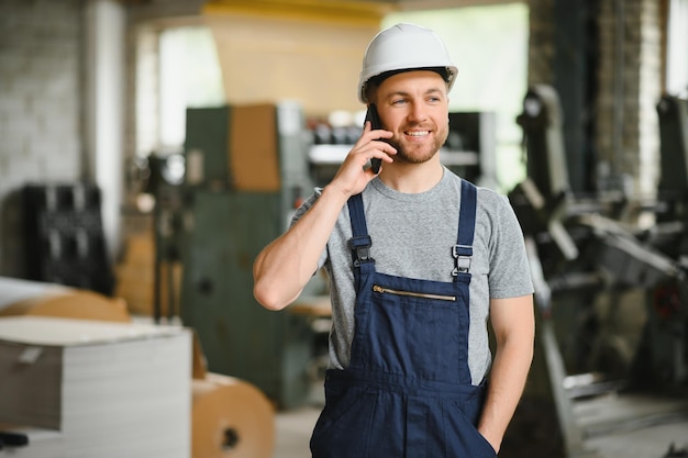 Management team engineer or foreman standing checking job\
information about industrial production management within the\
factory by phone teamwork concept