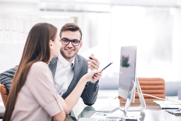 Il manager e il contabile sono seduti e discutono di grafici finanziari con i profitti dell'azienda sul posto di lavoro in ufficio. la foto ha uno spazio vuoto per il testo