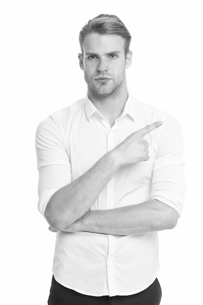 Manager or assistant help find direction Pointing direction Man shop assistant pointing index finger isolated on white Look at this advertisement This way concept Guy handsome shows direction