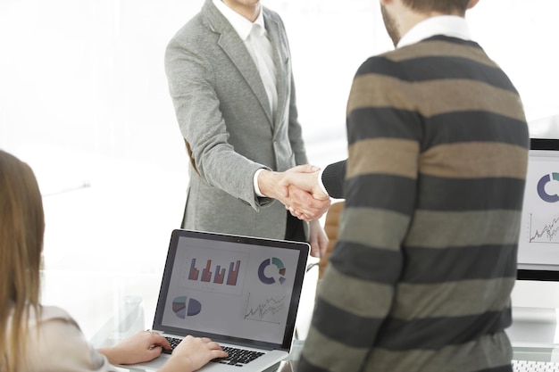 Photo manager and the client shake hands when meeting in the office