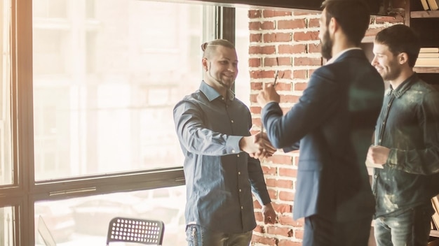 Photo manager of the company welcomes the customer with a handshake in
