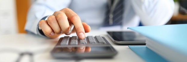 Manager counts on calculator sitting in the office