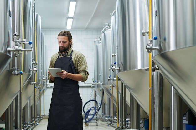 Manager die het werk van de brouwerij controleert