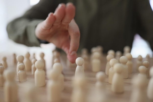 Manager die houten mensenfiguren op haar tafel verplaatst, close-up beheert personeel, huurt werknemers in en