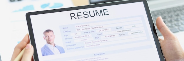 Photo manager examines applicant electronic questionnaire on tablet. job search and resume writing concept