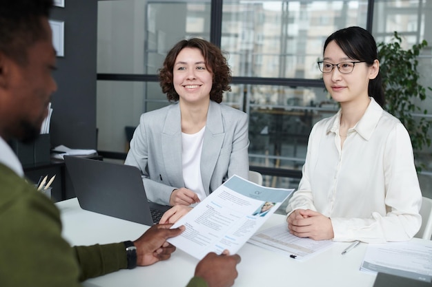 Manager examining resume of candidate at meeting