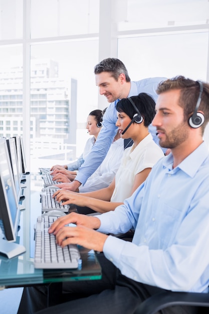 Manager and executives with headsets using computers