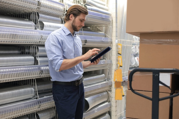 Foto manager gebruikt zijn tablet voor het online controleren van beschikbare producten.