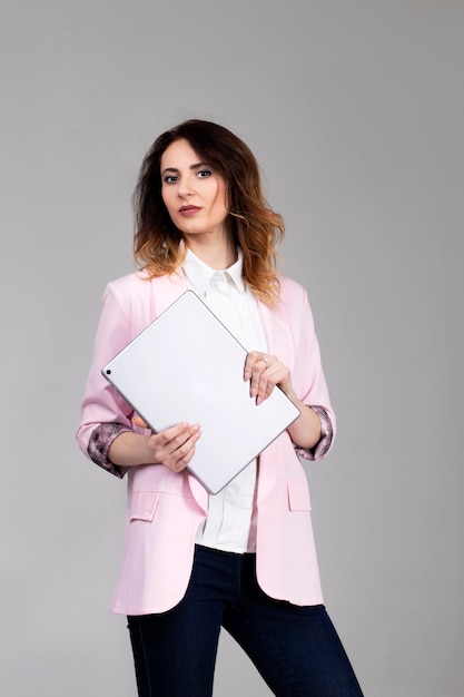 Manager girl in a jacket and white shirt with a tablet