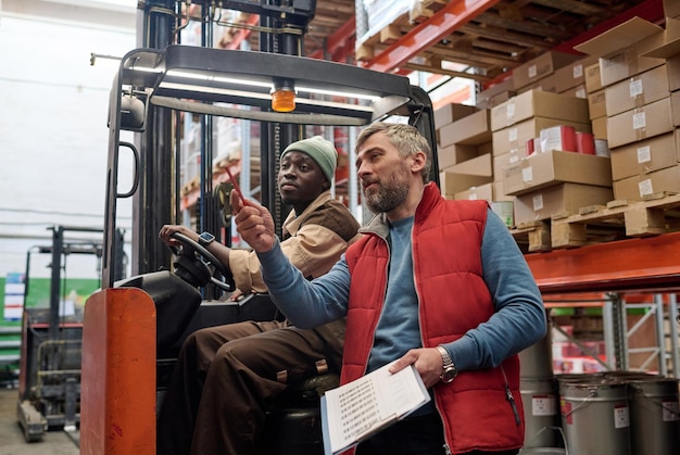 Manager giving instructions to forklift worker