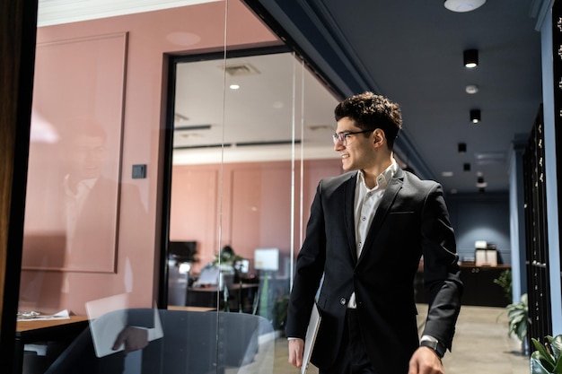 A manager in glasses and a business suit works in an office coworking space