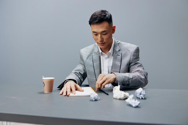 Manager in a gray suit crumpled paper office official emotions\
gray background