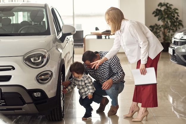 The manager helps the young family choose the most comfortable car for the city.