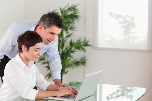 Manager and his secretary working with a laptop