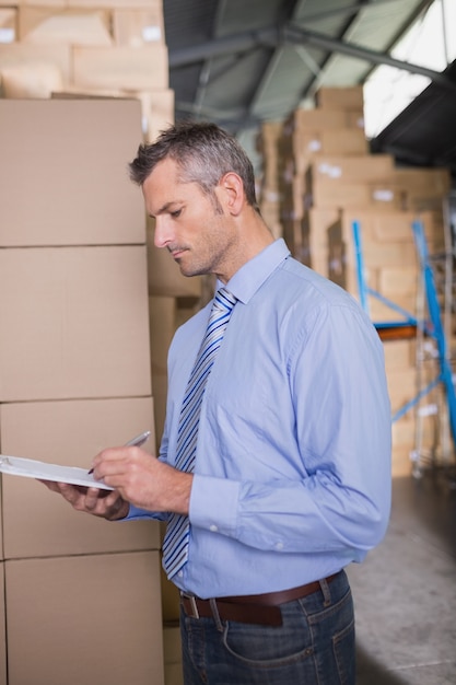 Manager holding clipboard in warehouse