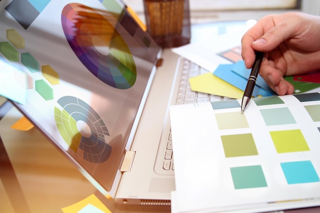 manager is choosing a color on a laptop for design project