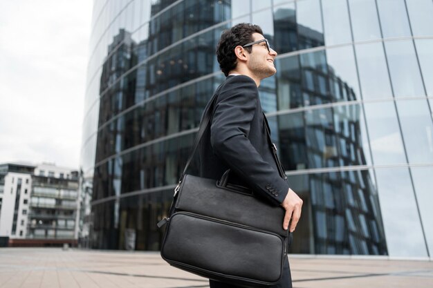 Photo the manager is a man with glasses going to the office for work in a business suit and a bag