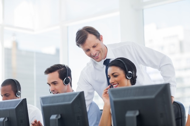 Manager listening to call centre employee 