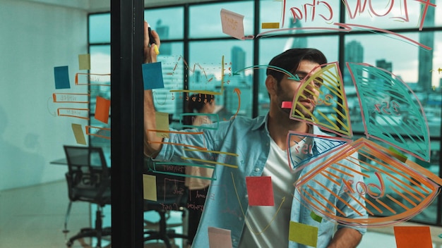 Manager looking sticky notes at glass wall while planing strategy tracery