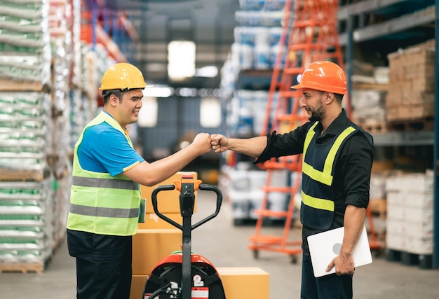 Manager man en fabrieksarbeiders of ingenieur vuist handstoot voor overeenkomst of succes bij werken in magazijnopslag magazijnmedewerkers die plezier hebben en vuist stoten tijdens het begin beginnen te werken