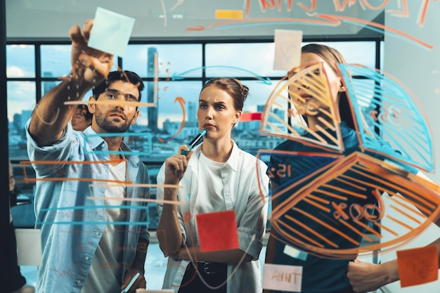 Photo manager pointing at glass wall while coworker thinking about plan tracery