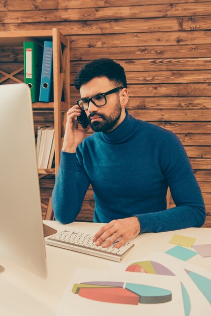 Manager praten over de telefoon met zijn klanten en werken met pc