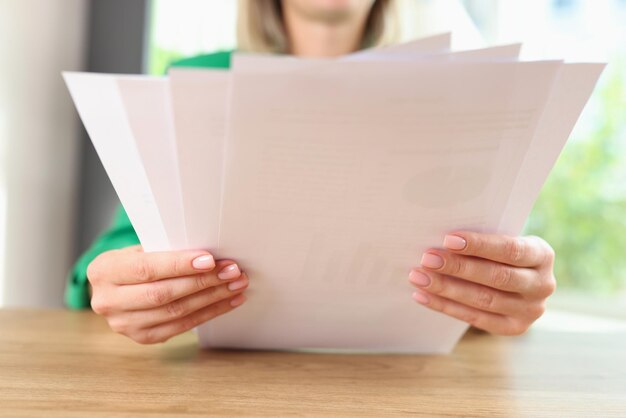 Manager reads documents while sitting at office desk business woman makes paperwork and holds