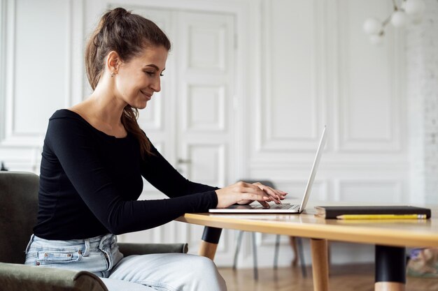Менеджер отвечает клиентам по электронной почте Дизайнер сидит в интернете Женщина в офисе дома