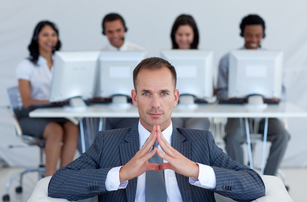 Manager sitting in call center in front of his team