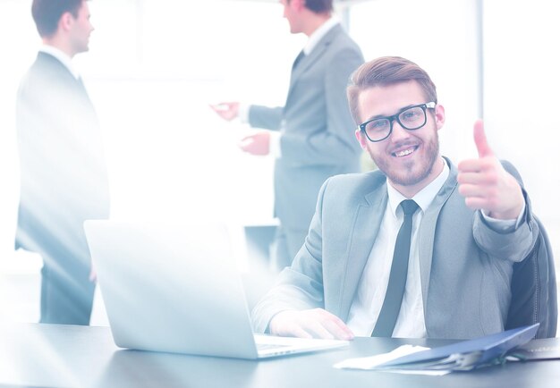 Manager sitting at his desk and showing thumbs up