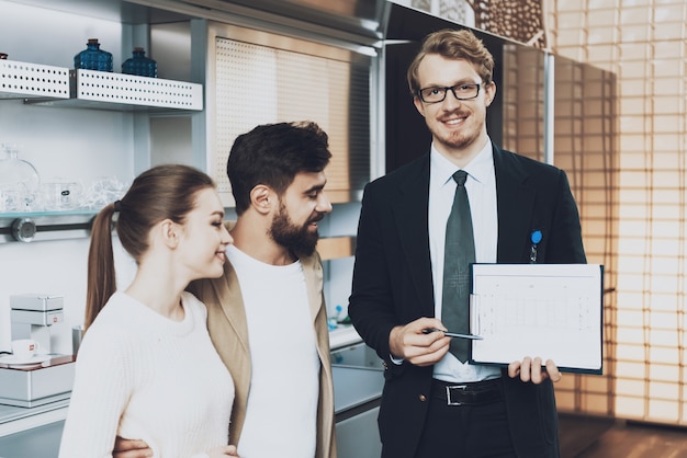 Manager in suit looking at camera showing blueprints