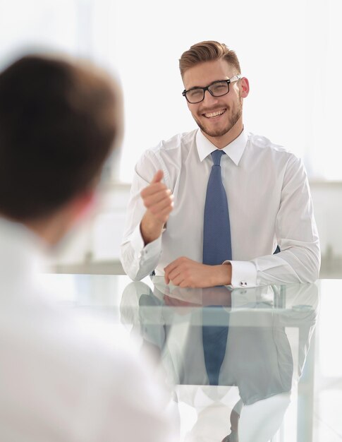 Manager talks to the employee sitting at his Deskbusiness concept