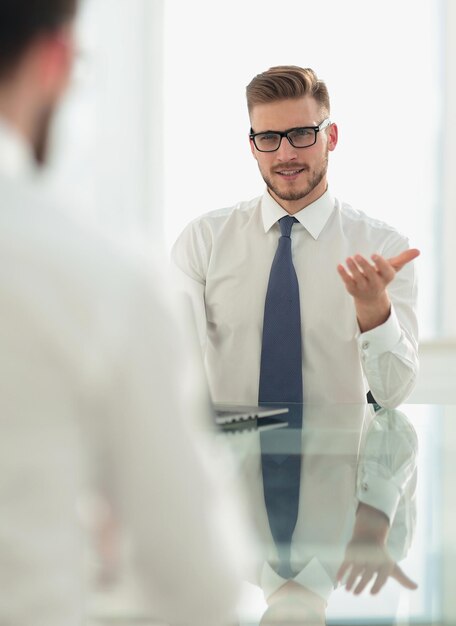 Manager talks to the employee sitting at his Deskbusiness concept