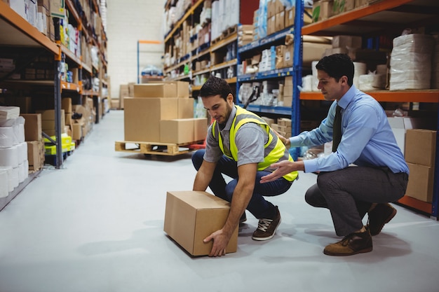 Manager training werknemer voor gezondheids- en veiligheidsmaatregelen in een groot magazijn