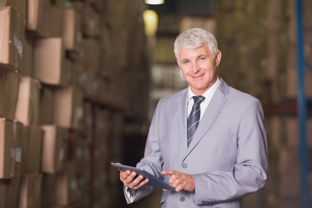 Manager using digital tablet in warehouse