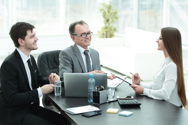 Manager werkkwesties bespreken met zijn assistenten achter een bureau