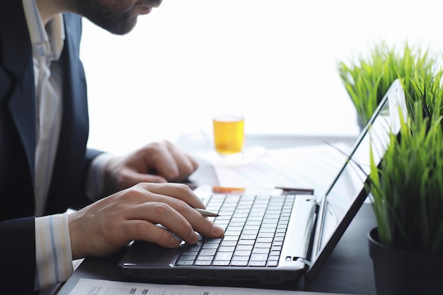 Manager werkt op een laptop op kantoor. Zakenman maakt een online transactie. Handelen op de beurs via internet.