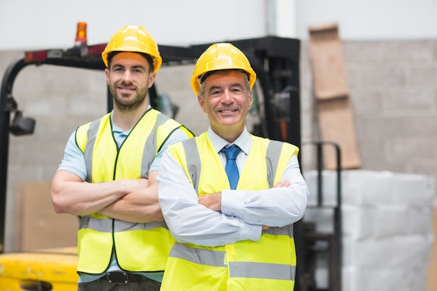 Manager with arms crossed and his colleague behind him