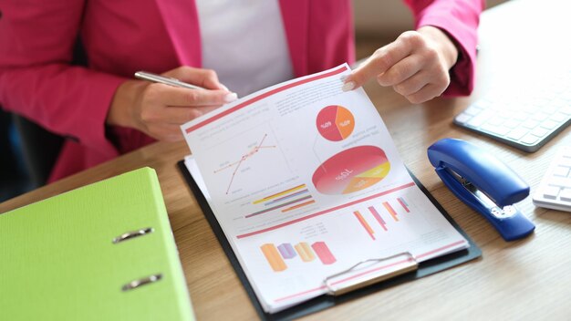 Manager working with financial reports while sitting at table in office business woman checks