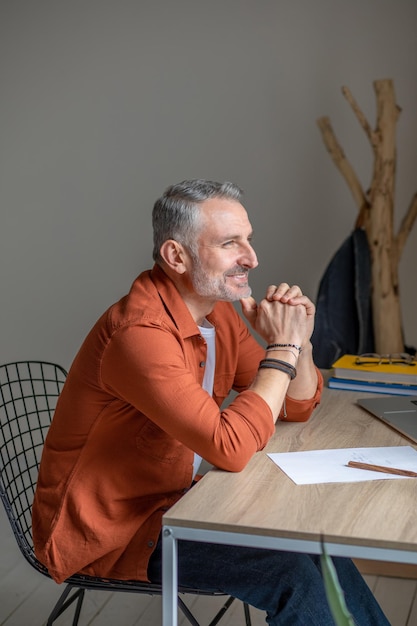 Manager zit aan de tafel op kantoor en kijkt bedachtzaam