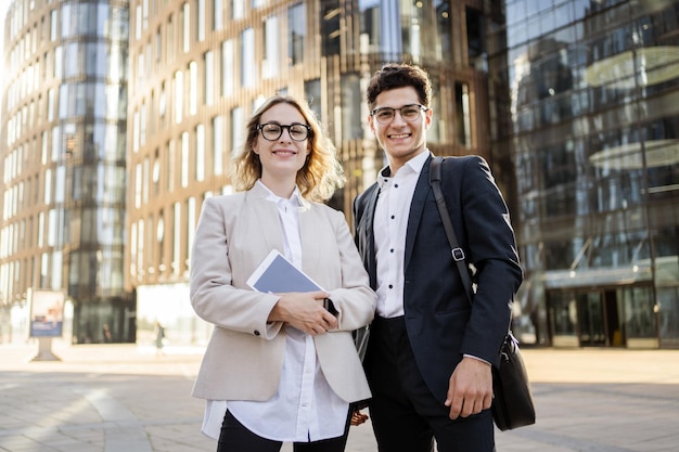 Managers and partners in formal clothes go to the new office a woman uses a phone in her hands