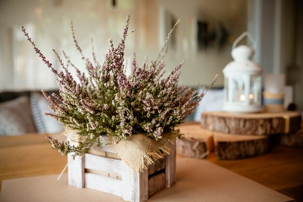 Mand met heide op tafel. Heide in een mand. roze en paarse bloemen heide, heide in houten kist, herfst planten en lantaarn. landhuis. Seizoensdecoraties