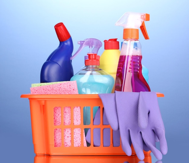 Mand met schoonmaakartikelen op blauwe achtergrond
