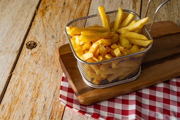 Mand vol frietjes op rustieke houten tafel