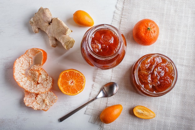 Mandarijn en kumquat jam in een glazen pot op whitewood