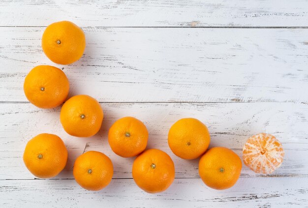 Mandarijnen met gesneden fruit over houten tafel met kopieerruimte